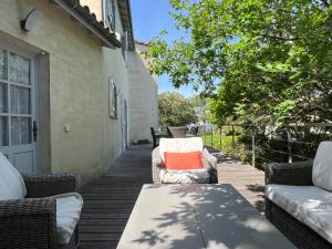 a patio with a table and chairs on a porch at Maison Albatros in Pyla-sur-Mer