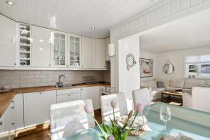 a kitchen and living room with a table and chairs at The Reine Scenic View in Moskenes
