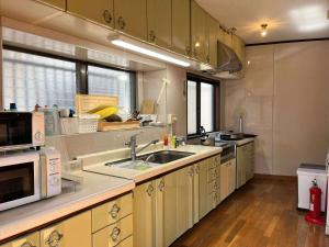 a large kitchen with a sink and a microwave at Island Base Shimami in Nobeoka