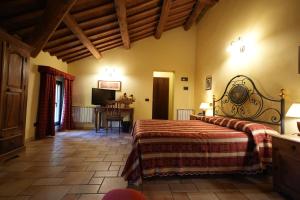 a bedroom with a bed and a table in a room at Hotel Antico Casale in Vigarano Mainarda