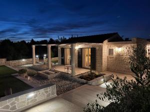 a house with lights in the yard at night at Villa Maginja in Sutivan