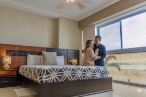a man and woman standing next to a bed in a bedroom at Puerto Santa Ana, river view 102 in Guayaquil