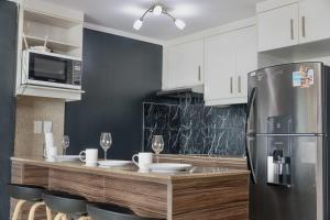 a kitchen with white cabinets and a stainless steel refrigerator at Puerto Santa Ana, river view 102 in Guayaquil
