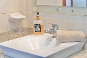 a soap bottle is sitting on a bathroom sink at Puerto Santa Ana, river view 102 in Guayaquil +11 photos