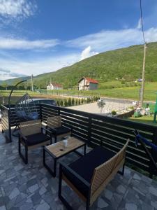 a patio with tables and chairs and a playground at Apartman Demirovic in Orašac