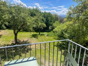 a bench on a balcony with a view of a park at Pension Victoria in Millstatt
