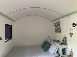 a small room with a bed and a tv at Apple Orchard Shepherd Huts in Staple Cross