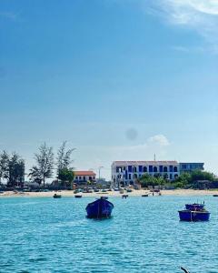 a group of boats in the water near a beach at Homestay Nhà Có Gió in Thôn Mỹ Tường