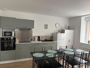 a kitchen with a table and chairs in a room at LONI Expériences moderne emplacement idéal in Challans