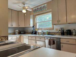 a kitchen with white cabinets and a sink and a window at 3BR 3BA Beach House in Kitty Hawk Beach +34 photos