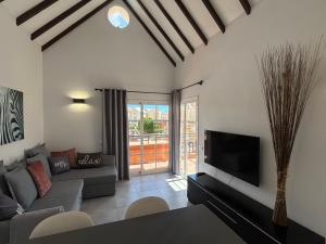 a living room with a couch and a tv at Yucca Park ApartHotel in Adeje