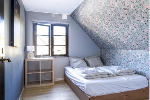 a small bedroom with a bed and a floral wall at Grevie skogsvilla in Grevie