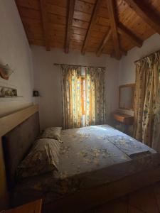 a bedroom with a bed in a room with wooden ceilings at Villa Amfithea in Skiathos