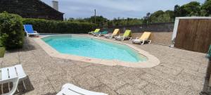 a pool with chaise lounge chairs and a bunch at Casal do Vulcão in Capelo