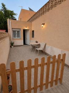 a wooden fence in front of a patio with a table at Costacabana Sea Apartment in Almería +5 photos