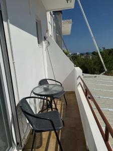 two chairs and a table on a balcony at Zografos 5 in Haraki