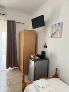 a room with a bed and a tv on the wall at Zografos 5 in Haraki +1 photo