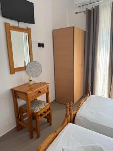 a bedroom with a bed and a table with a mirror at Zografos 5 in Haraki