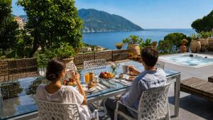 a man and a woman sitting at a table with a meal at Villa Carpediem - Luxury Private Stay Front Sea Portofino Coast in Recco +16 photos
