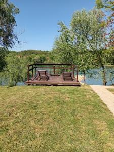 a wooden deck with benches sitting on top of a body of water at Una, Home on river bank in Spilja