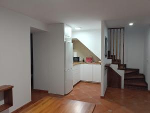 a kitchen with white cabinets and a staircase at Casa La Piedra in Constantina