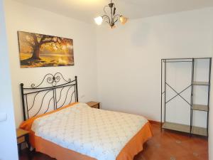 a bedroom with a bed and a painting on the wall at Casa La Piedra in Constantina +1 photo