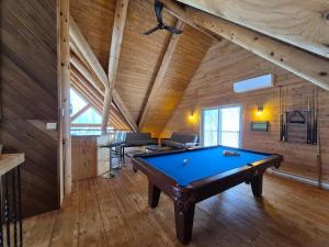 a pool table in a room with a wooden ceiling at Le Cormoran in Sainte Brigitte de Laval