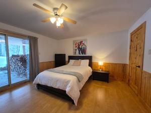 a bedroom with a bed and a ceiling fan at Le Cormoran in Sainte Brigitte de Laval