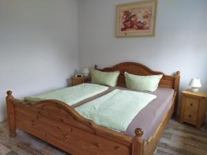 a bedroom with a wooden bed with two pillows at Ferienwohnung Schwerg in Hohnstein