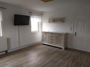 an empty room with a flat screen tv on the wall at Ferienwohnung Schwerg in Hohnstein