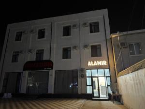 a white building with an alamine sign on the front at ALAmir Khiva in Khiva