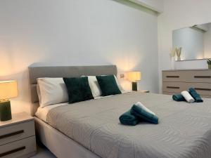 a bedroom with a bed with two blue pillows on it at Wake to Lake - Arona, Lago Maggiore in Arona