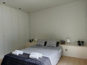 a bedroom with a bed with towels on it at Ednas Place - Tranquilidade e Natureza in Caminha