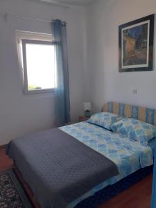 a bed in a bedroom with a window and a bedspread at Apartments Smokva in Opatija