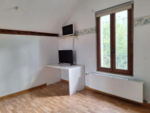 a room with a desk with a television and a window at Ô Cottage La Barre Ormesson - 20 min Paris in Deuil-la-Barre
