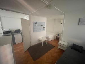 a living room with a white room with a table at Mókus Pagony 2pont0 in Zánka