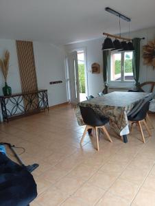 a living room with a table and chairs in it at Maison de campagne in Capelle-Fermont
