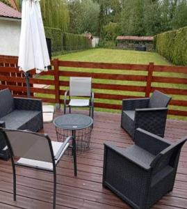 a patio with chairs and tables and an umbrella at Maison de campagne in Capelle-Fermont +1 photo