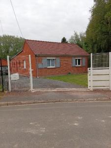 a house with a white fence in front of it at Maison de campagne in Capelle-Fermont