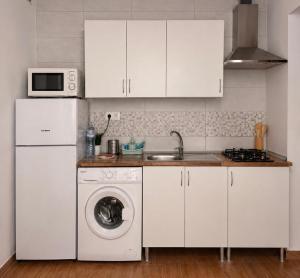a kitchen with white cabinets and a washing machine at Costacabana Sea Apartment in Almería