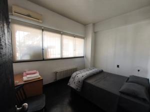 a small bedroom with a bed and a window at Libertador 2 in Montevideo