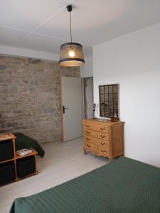 a bedroom with a bed and a dresser and a sink at Gite La Ferme in Arinthod