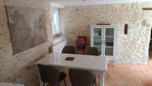 a dining room with a white table and chairs at Douce Campagne in Clermont-Créans