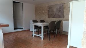 a dining room with a white table and chairs at Douce Campagne in Clermont-Créans