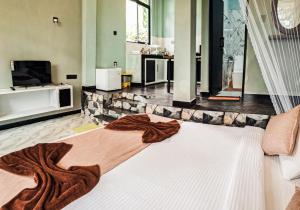 a living room with a large bed with a blanket at Nice View Guest House & Restaurant in Ella