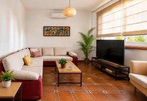 a living room with a couch and a tv at Deluxe Mogán Beach Apt 1 in Puerto de Mogán