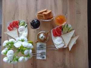 a table with two plates of food and eggs and fruit at Like House Karakol in Karakol