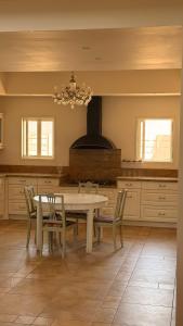 a kitchen with a table and chairs and a stove at נורית בעמק in Gan Yoshiyya +28 photos