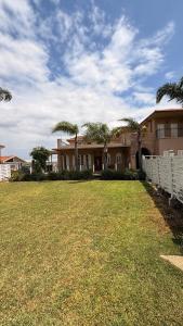 a large house with palm trees in a yard at נורית בעמק in Gan Yoshiyya
