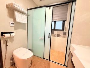 a bathroom with a toilet and a glass shower at 穗眠民宿SnoozeInn in Chishang +35 photos
